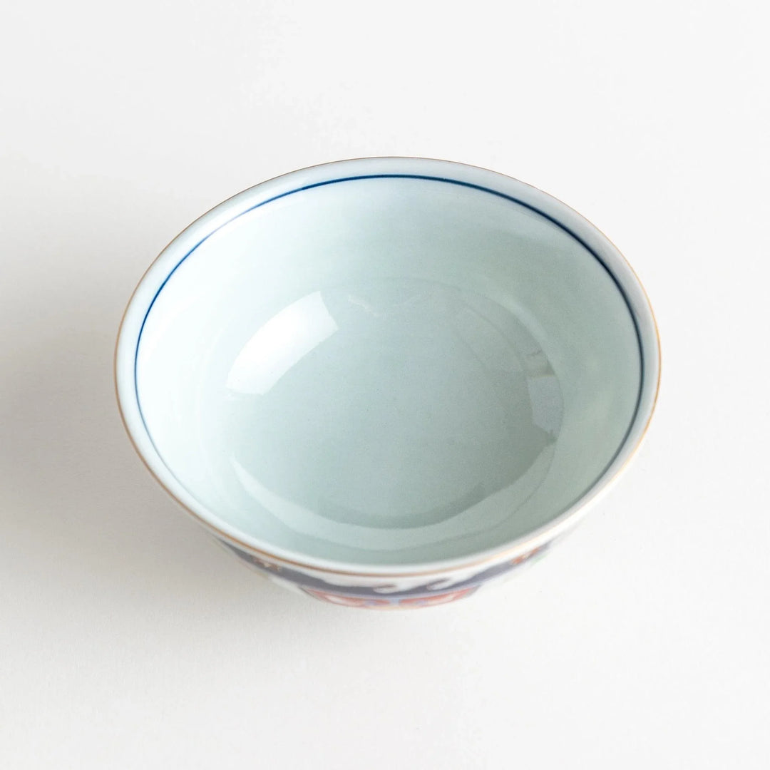 Porcelain bowl with traditional Japanese floral and geometric motifs in blue red and green with gold accents.