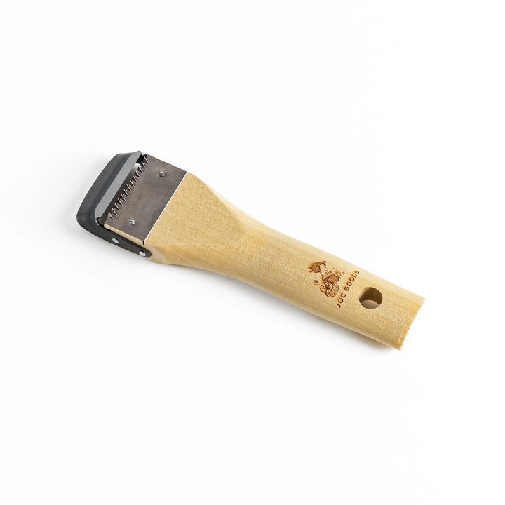 Wood handle julienne peeler with sharp stainless steel blade and JOC Goods logo for vegetable strips.