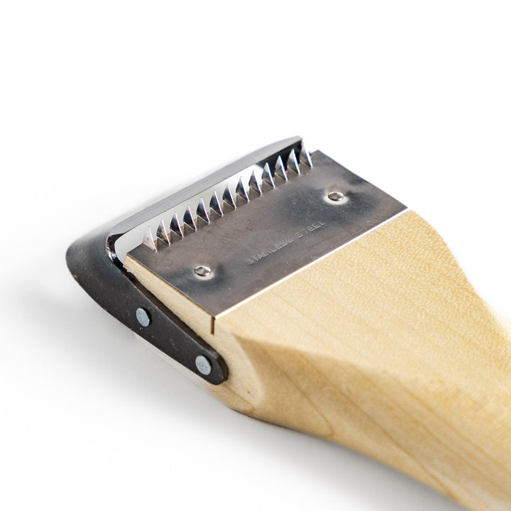 Wood handle julienne peeler with sharp stainless steel blade and JOC Goods logo for vegetable strips.