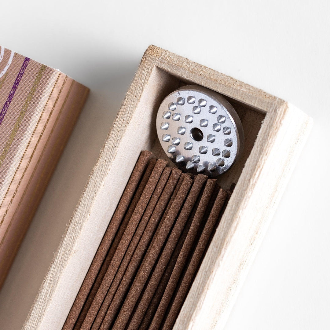 Japanese Palo Santo incense sticks neatly arranged in a wooden box with a decorative paper sleeve from Kyoto’s Kousaido