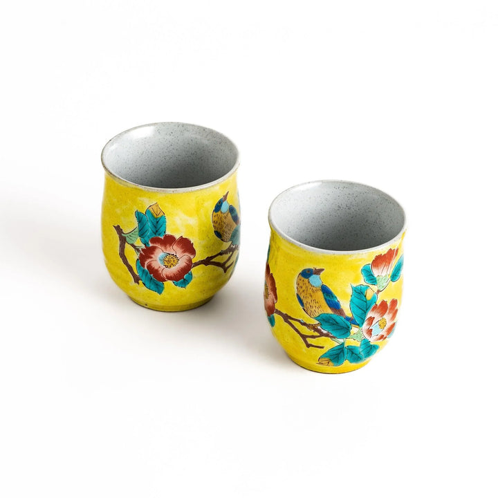 Two yellow teacups with a beautiful bird and flower design, perfect for sharing a moment with a loved one.