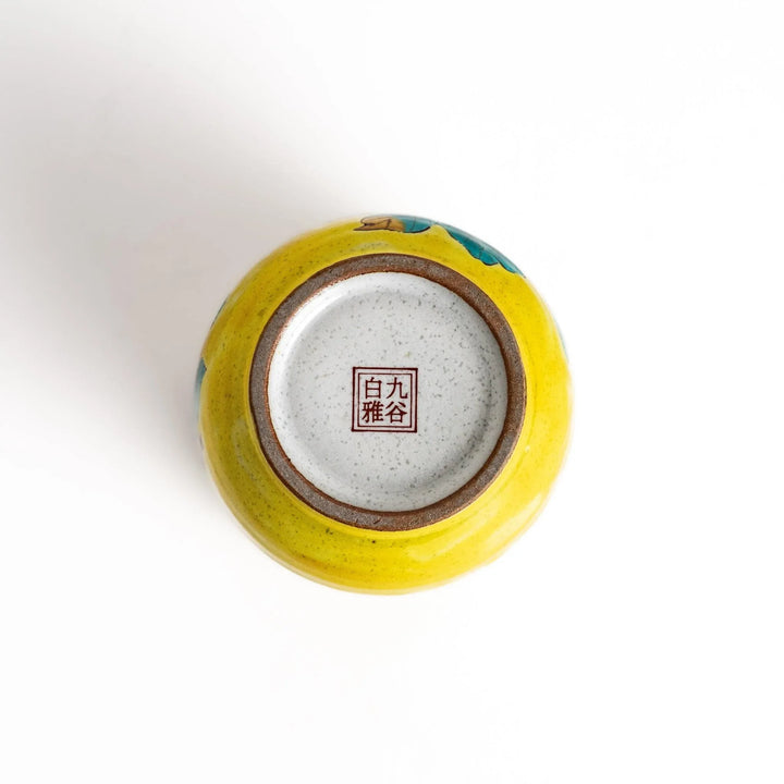 Yellow teacup with a colorful bird perched on a flowering branch, perfect for adding a touch of nature to your tea time.