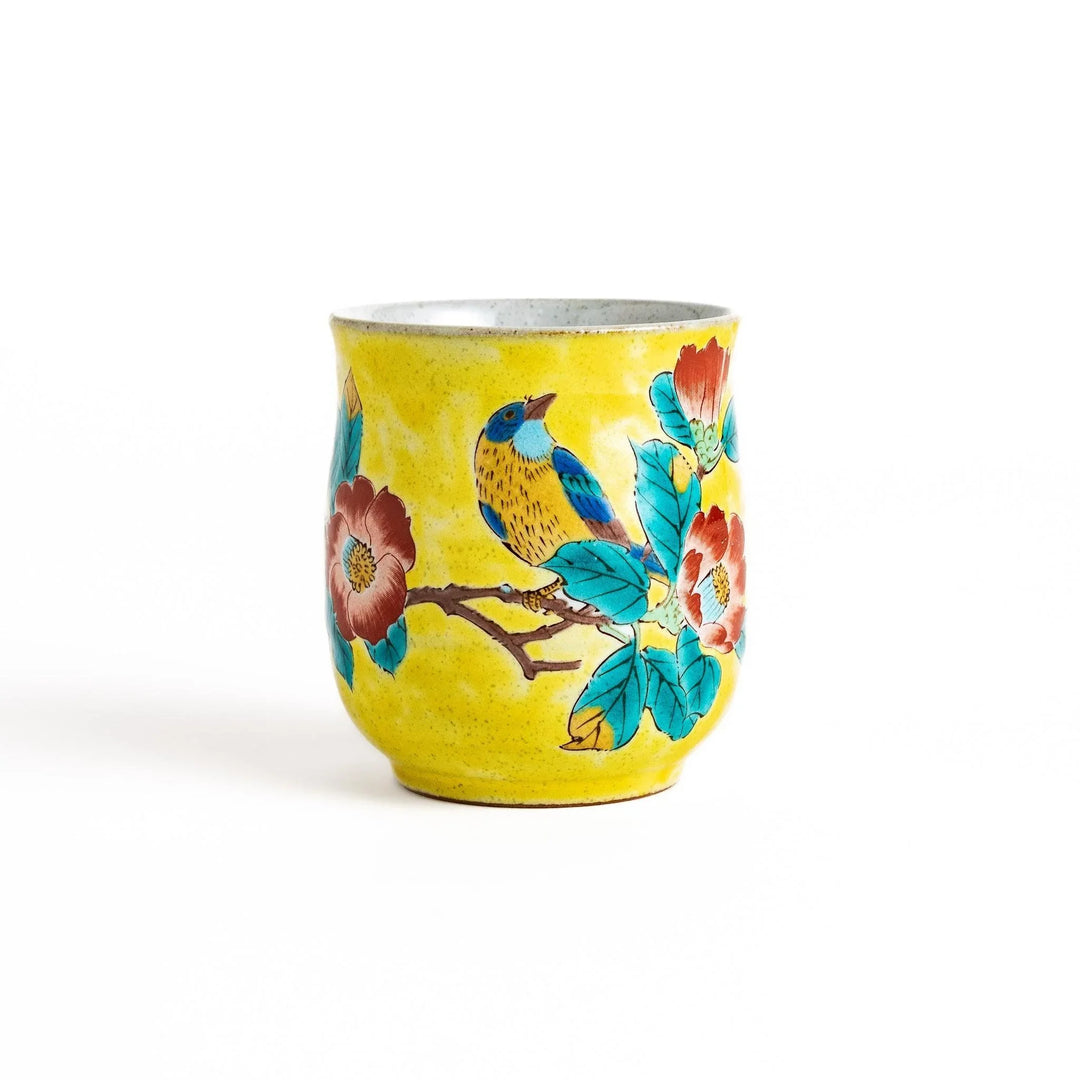 Yellow teacup with a colorful bird perched on a flowering branch, perfect for adding a touch of nature to your tea time.