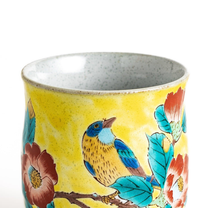 Yellow teacup with a colorful bird perched on a flowering branch, perfect for adding a touch of nature to your tea time.