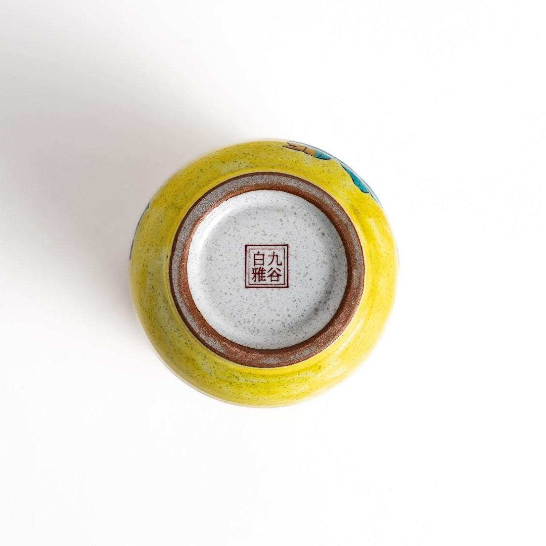 Yellow teacup with a colorful bird perched on a flowering branch, perfect for adding a touch of nature to your tea time.