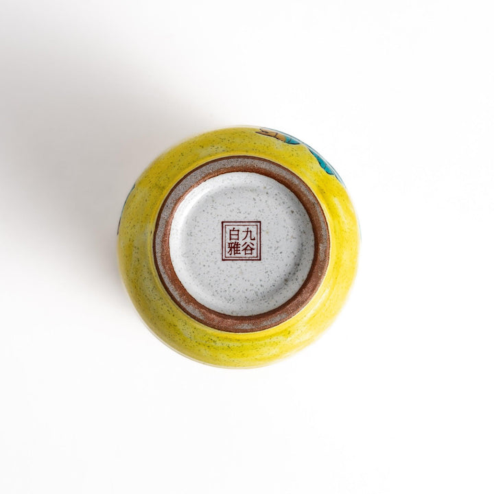 Yellow teacup with a colorful bird perched on a flowering branch, perfect for adding a touch of nature to your tea time.