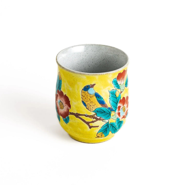 Yellow teacup with a colorful bird perched on a flowering branch, perfect for adding a touch of nature to your tea time.