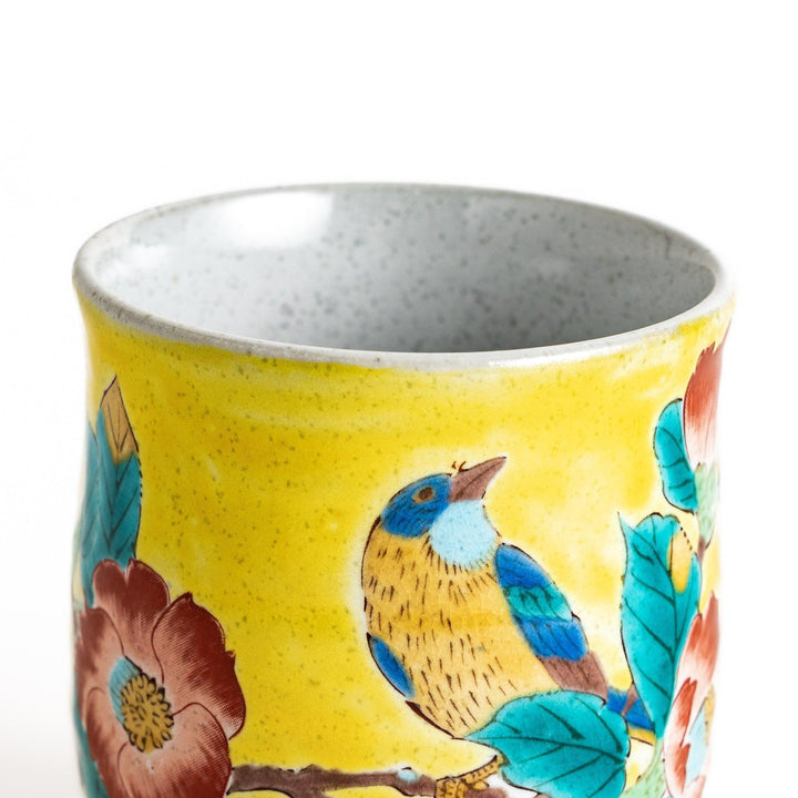 Yellow teacup with a colorful bird perched on a flowering branch, perfect for adding a touch of nature to your tea time.