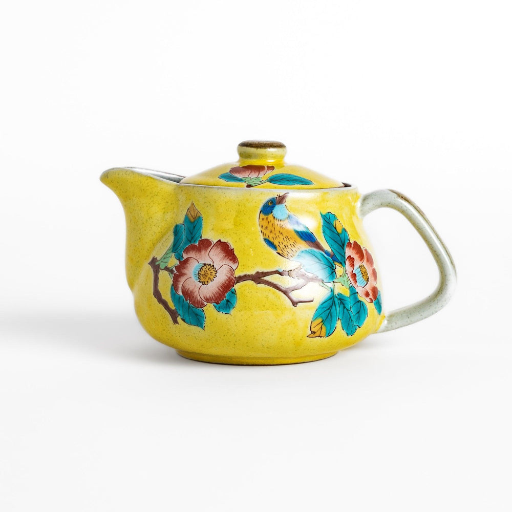 Charming yellow teapot featuring a vibrant bird and camellia design, perfect for adding a touch of elegance to your tea time.