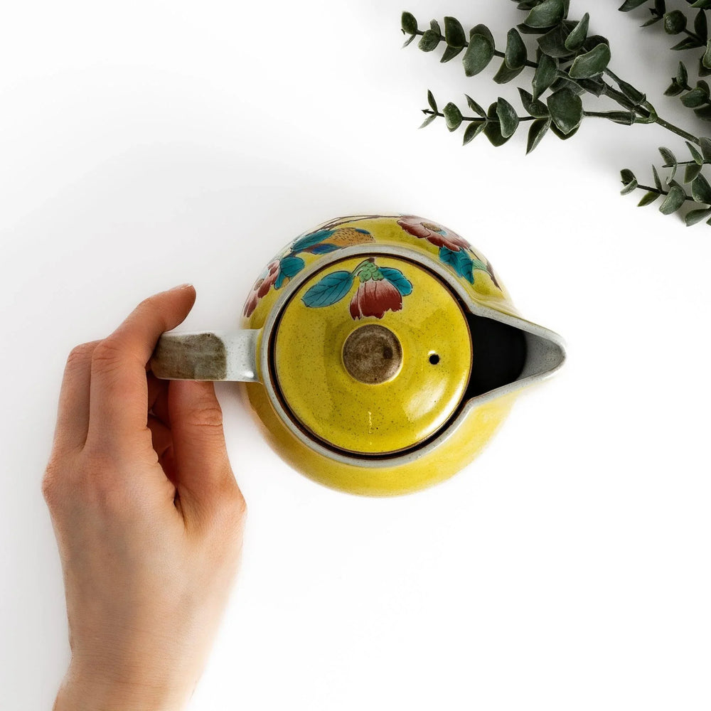Charming yellow teapot featuring a vibrant bird and camellia design, perfect for adding a touch of elegance to your tea time.