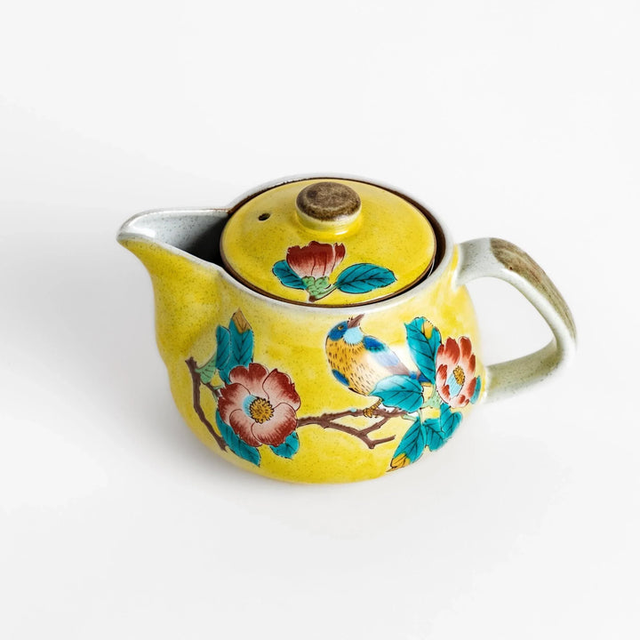 Charming yellow teapot featuring a vibrant bird and camellia design, perfect for adding a touch of elegance to your tea time.