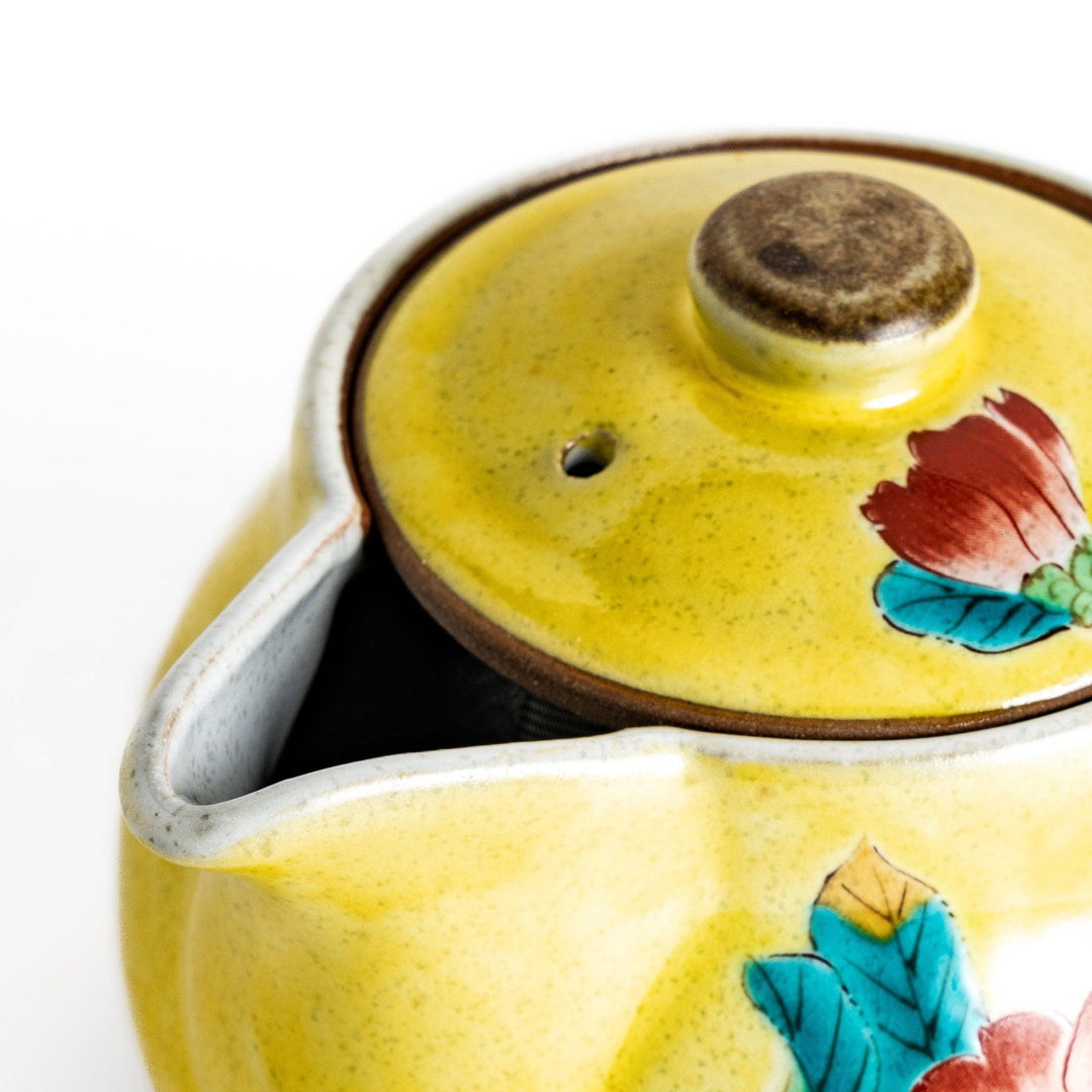 Charming yellow teapot featuring a vibrant bird and camellia design, perfect for adding a touch of elegance to your tea time.