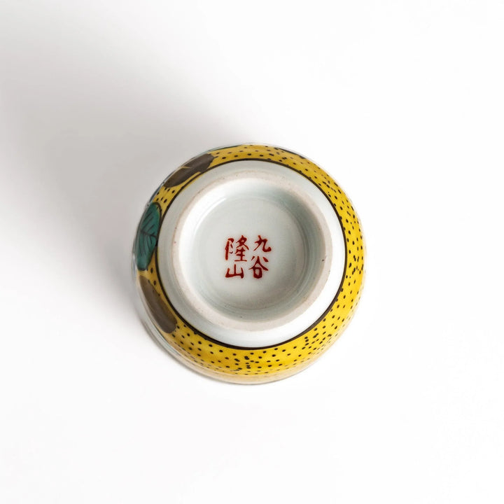 Yellow teacup with a colorful hydrangea pattern and green leaves, perfect for enjoying a cup of tea.