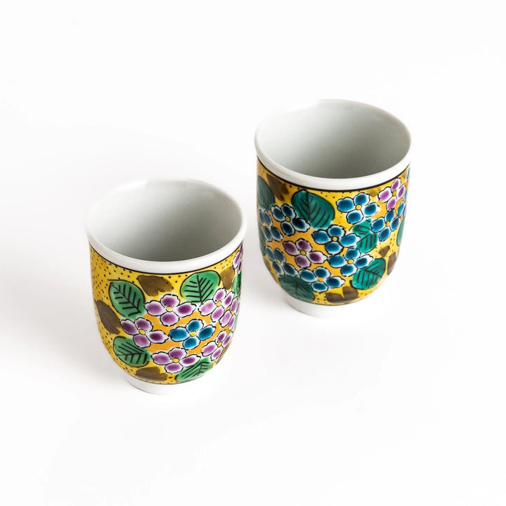 Two ceramic teacups with a vibrant yellow and blue hydrangea pattern, perfect for enjoying tea with a friend.