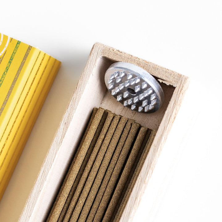 Japanese Yuzu incense sticks presented in a yellow box with circular patterns and a wooden holder, crafted by Kousaido Kyoto